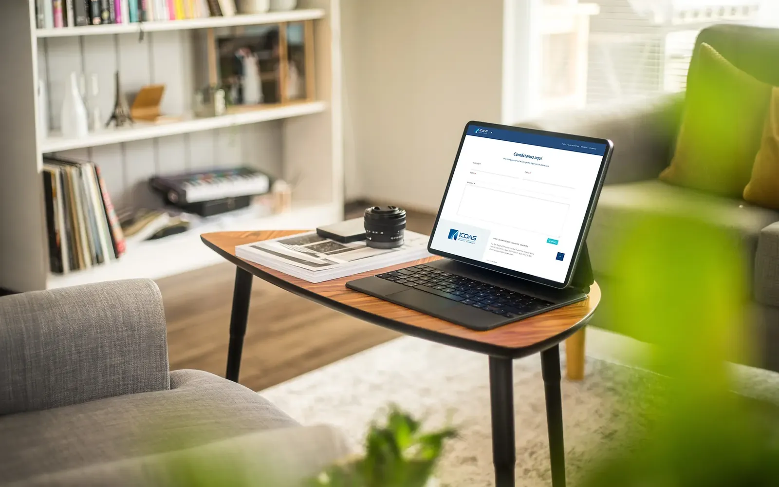 Página web de Icoas en un portátil sobre una mesa de salón