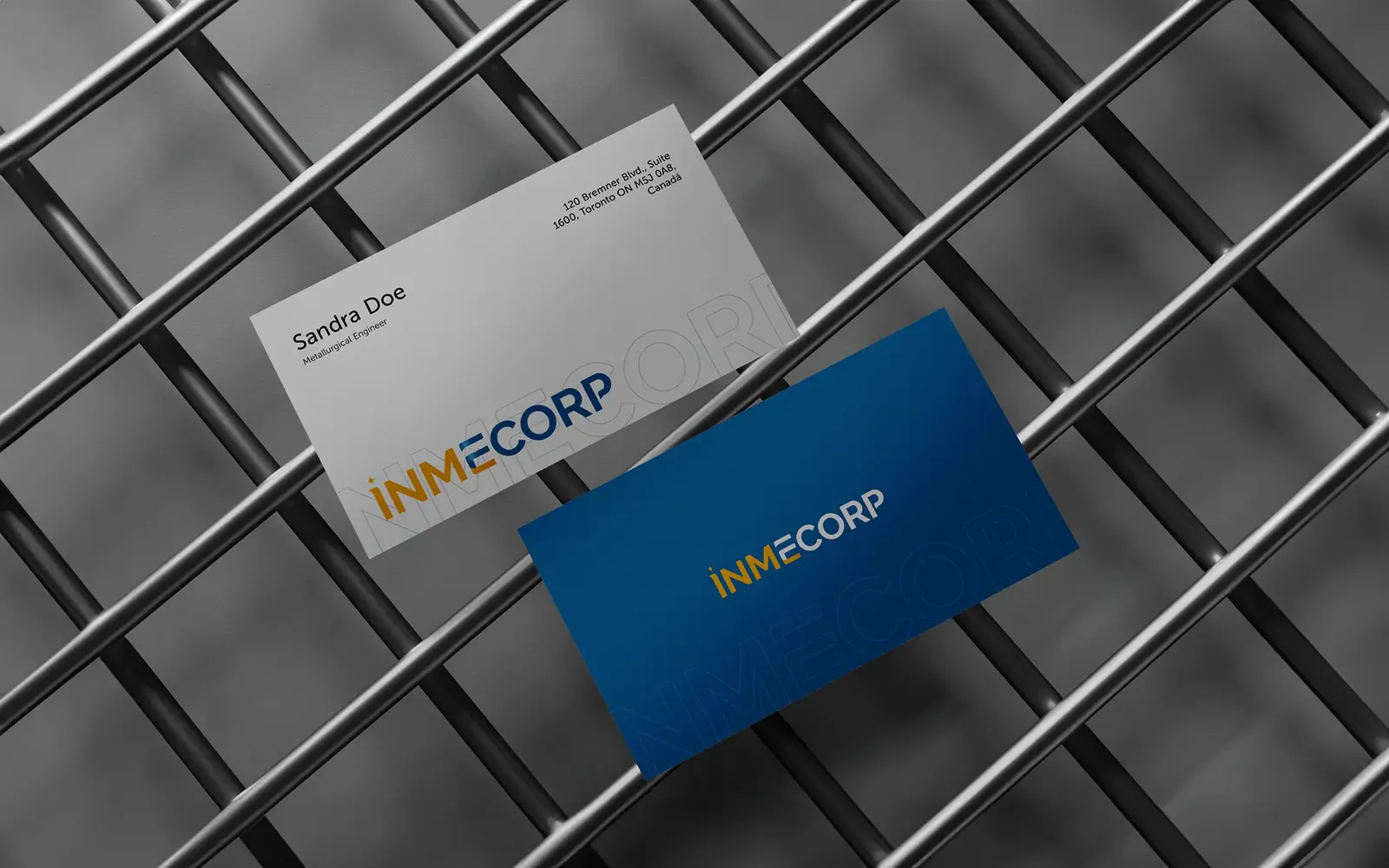 Tarjetas de visita de Inmecorp sobre una rejilla metálica