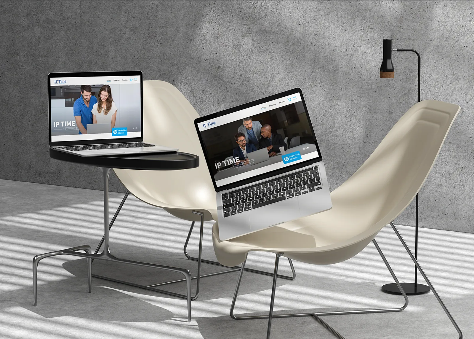 Página web de IP Time en dos portátiles junto a un sillón sobre hormigón